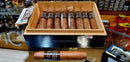 A wooden box containing multiple cigars, with each cigar resting in its individual slot. The box has a label that reads 'Classic Robusto - Brick House'.
