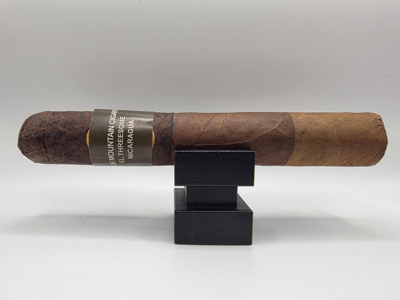 Cigar on a black stand against a white background - The Roller Ash - Blue Mountain Cigars - El Threesome