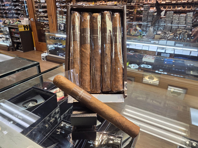 Packaged cigars with a single cigar displayed in front, priced at $12.99, in a store setting.

WD - Honey - Corona-2