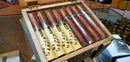 A box of Alec Bradley cigars, with the brand name visible on the cigars, displayed on a counter.