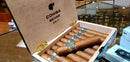 A box of Cohiba Behike 52 cigars displayed in a retail setting, with the cigars arranged neatly inside the open box.