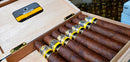 Cohiba Maduro cigars displayed in an open wooden case with a yellow and black label on top.