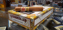 A box of Romeo Y Julieta Short Churchill Cigars with one cigar resting on top of the box.